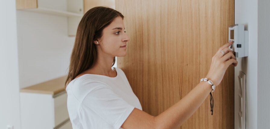 portrait of young woman adjusting thermostat in 4VF4V6P scaled